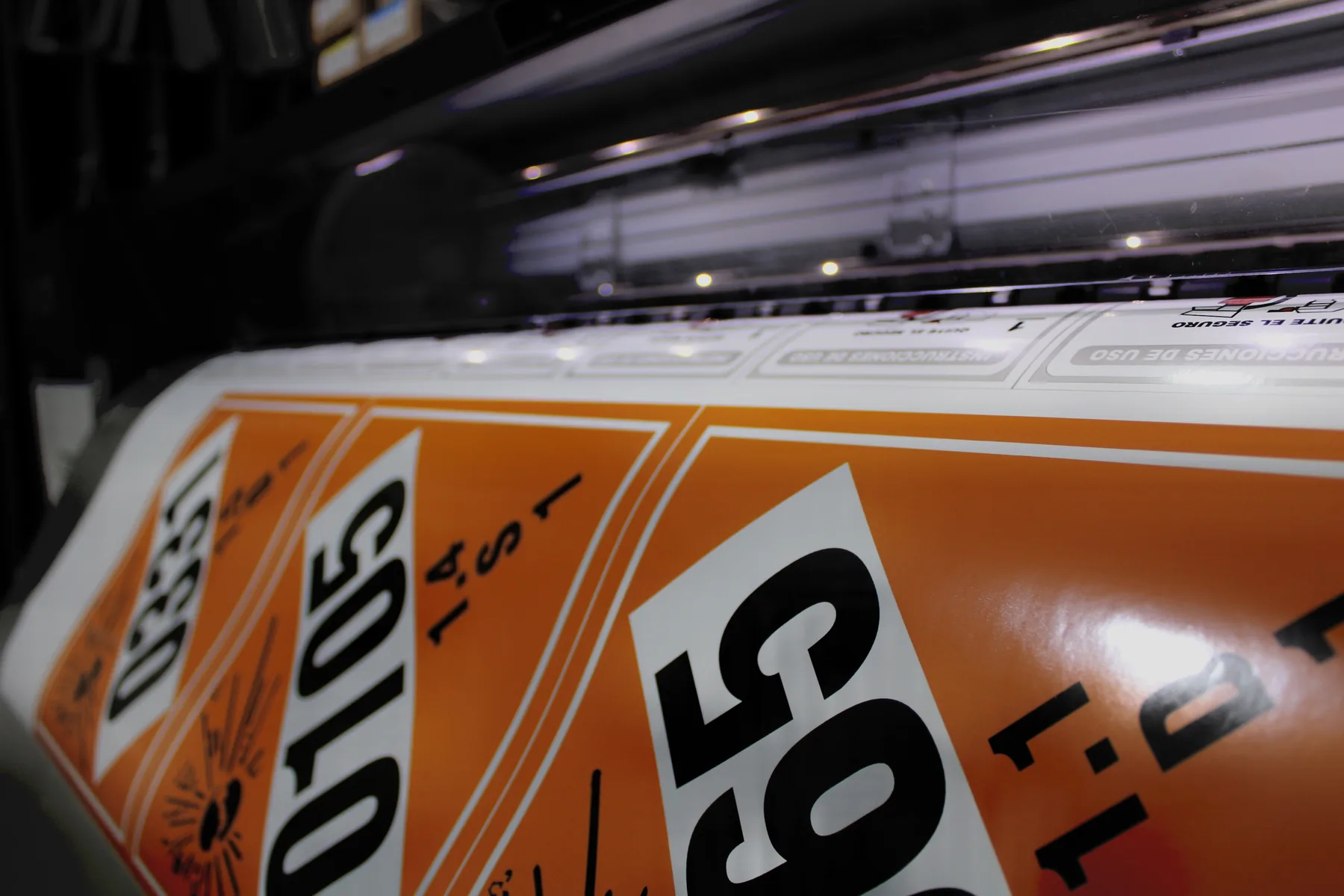 Plotter de gran formato imprimiendo señalización de seguridad en el taller de SISCA FIRE